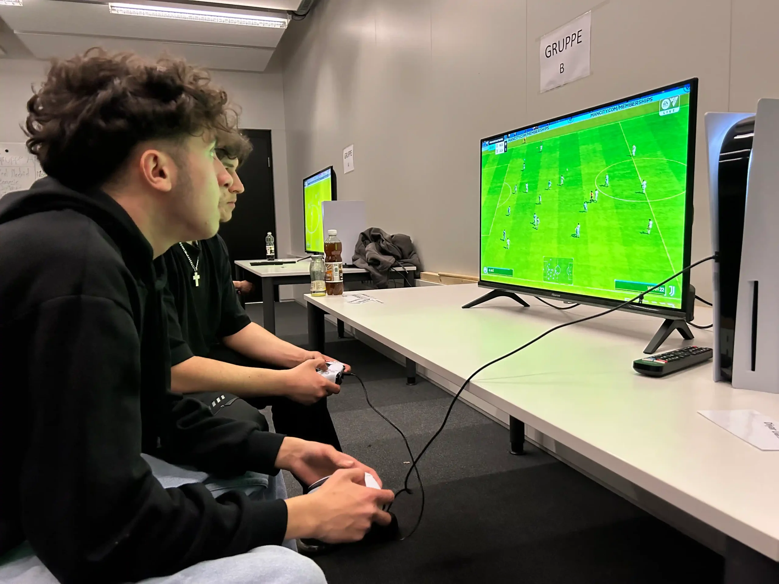 Junge Männer spielen ein Fußball-Videospiel gemeinsam.